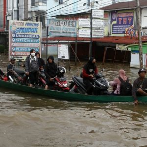 Jadi Ojek Perahu, Bocah 11 Tahun Mengais Rezeki di Tengah Banjir